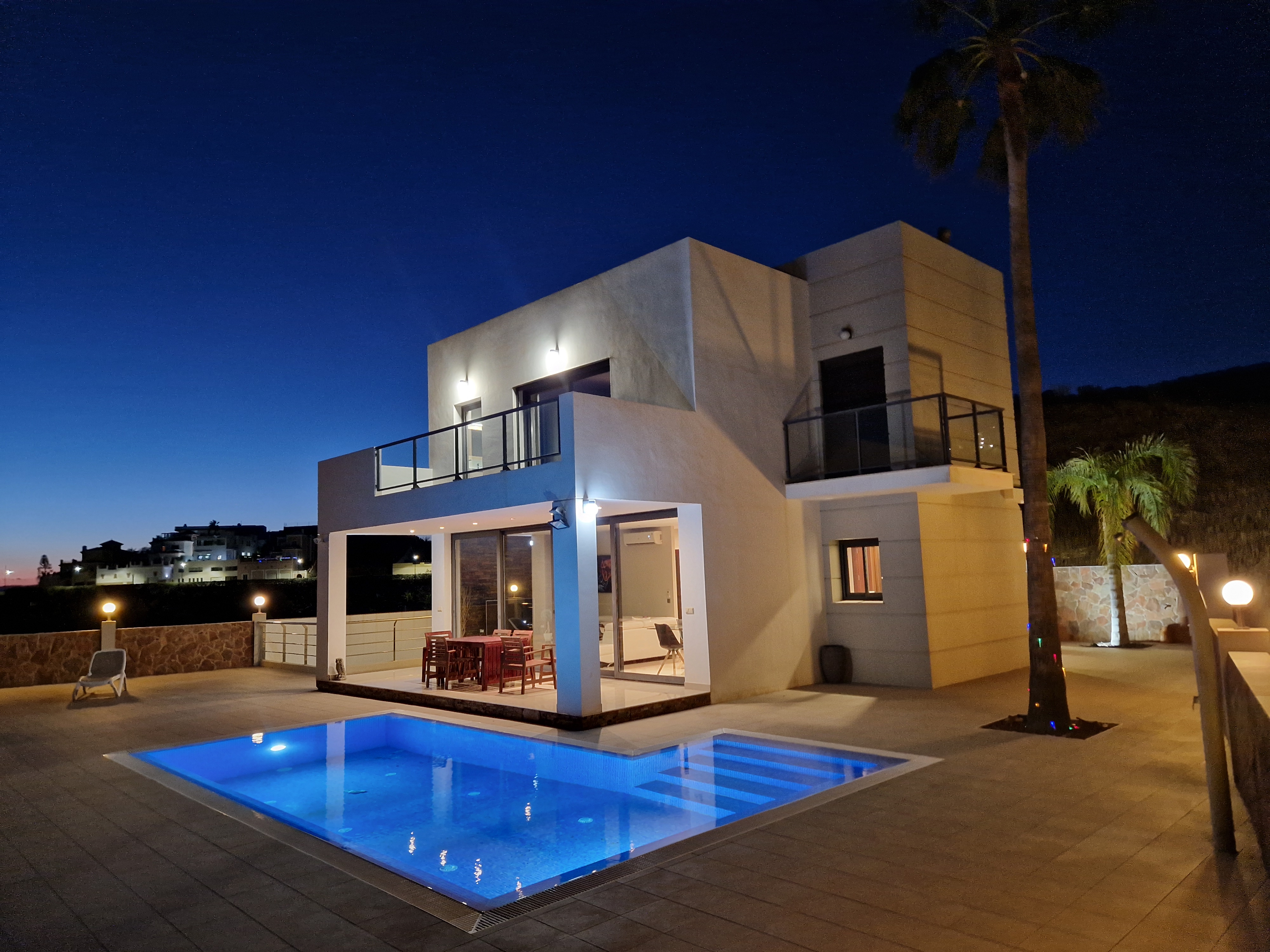 Villaen i Torrox med oplyst pool og terrasser om aftenen
